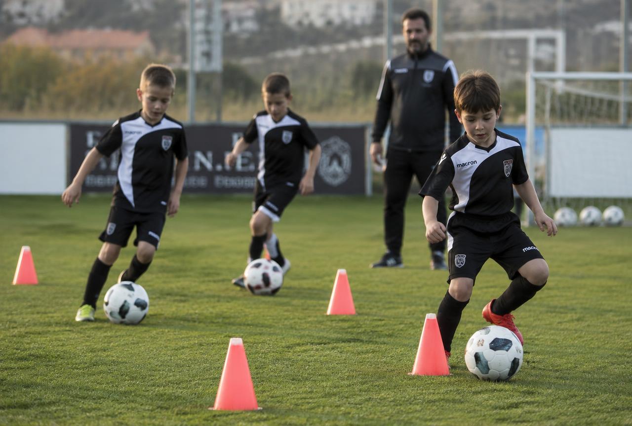 Bambini di una scuola calcio durante un allenamento sul campo in erba