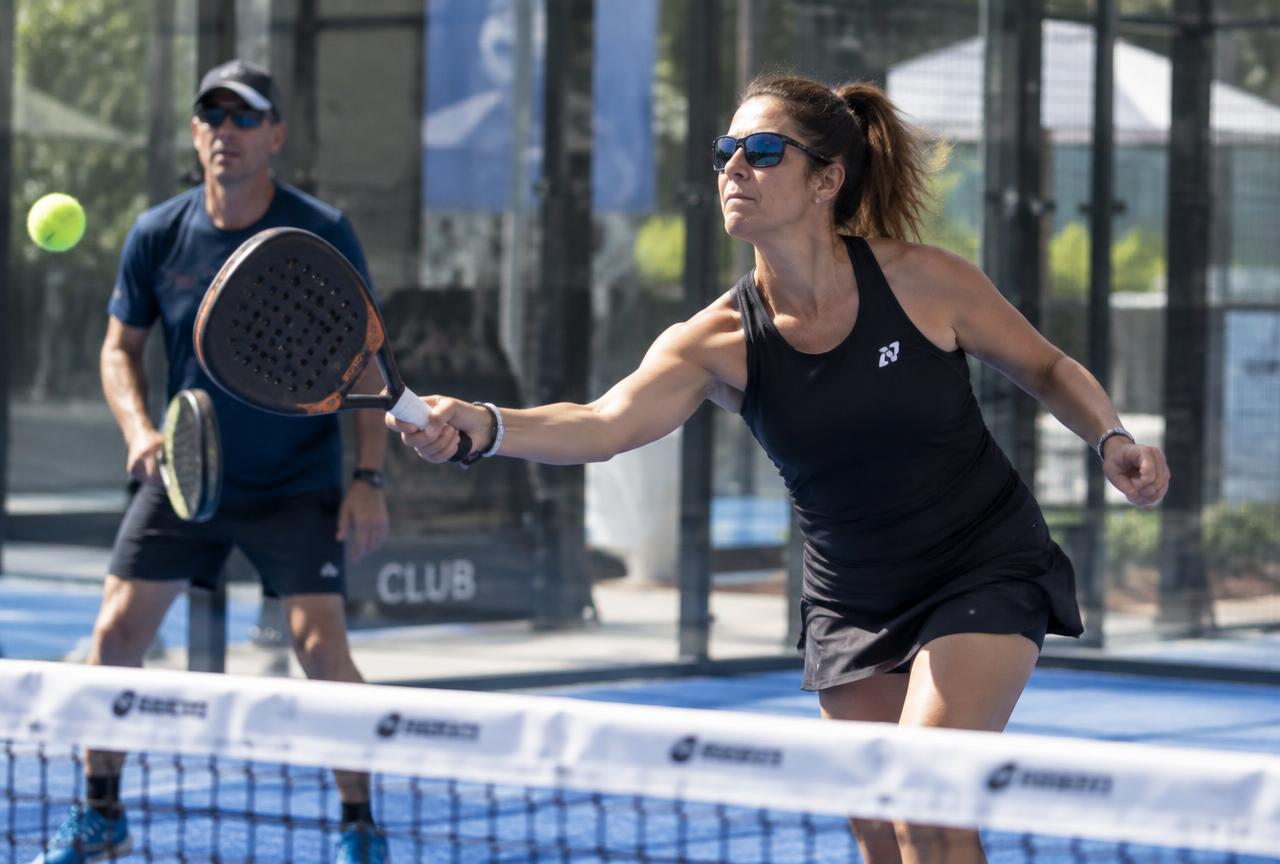 Giocatori impegnati in una partita di padel su un campo con pareti in vetro